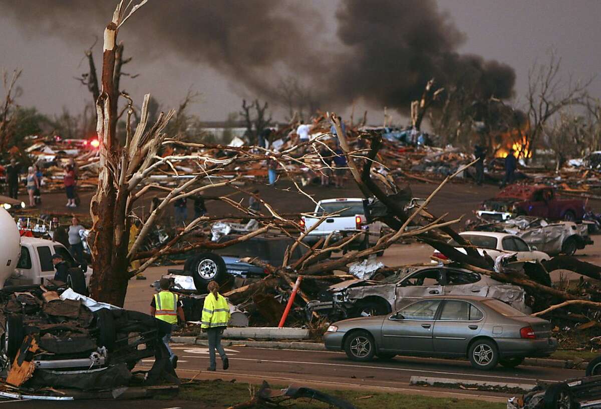 Emergency personnel walk through a neighborhood severely damaged by a tornado near the Joplin Regional Medical Center in Joplin, Mo., Sunday, May 22, 2011. A large tornado moved through much of the city, damaging a hospital and hundreds of homes and businesses.