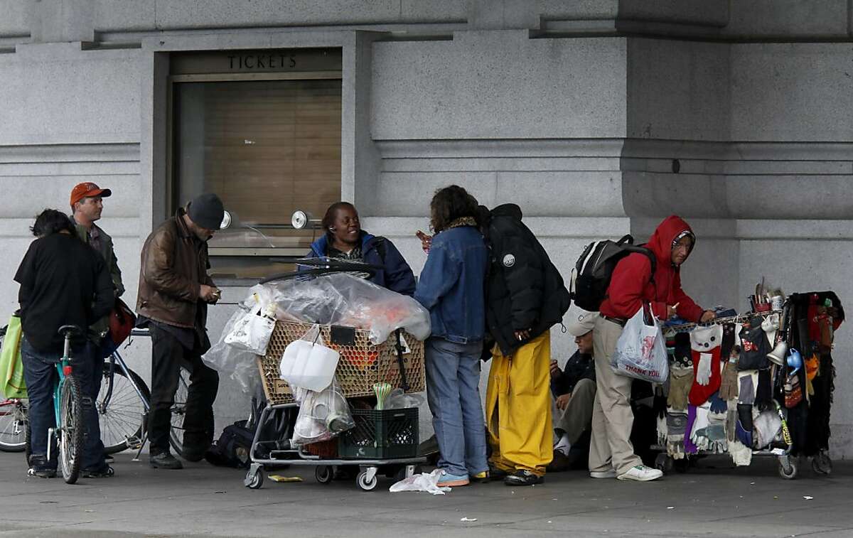 A group of homeless people stayed dry Monday May 16, 2011 under the overhang at the Bill Graham Civic Auditorium in San Francisco, Calif.
