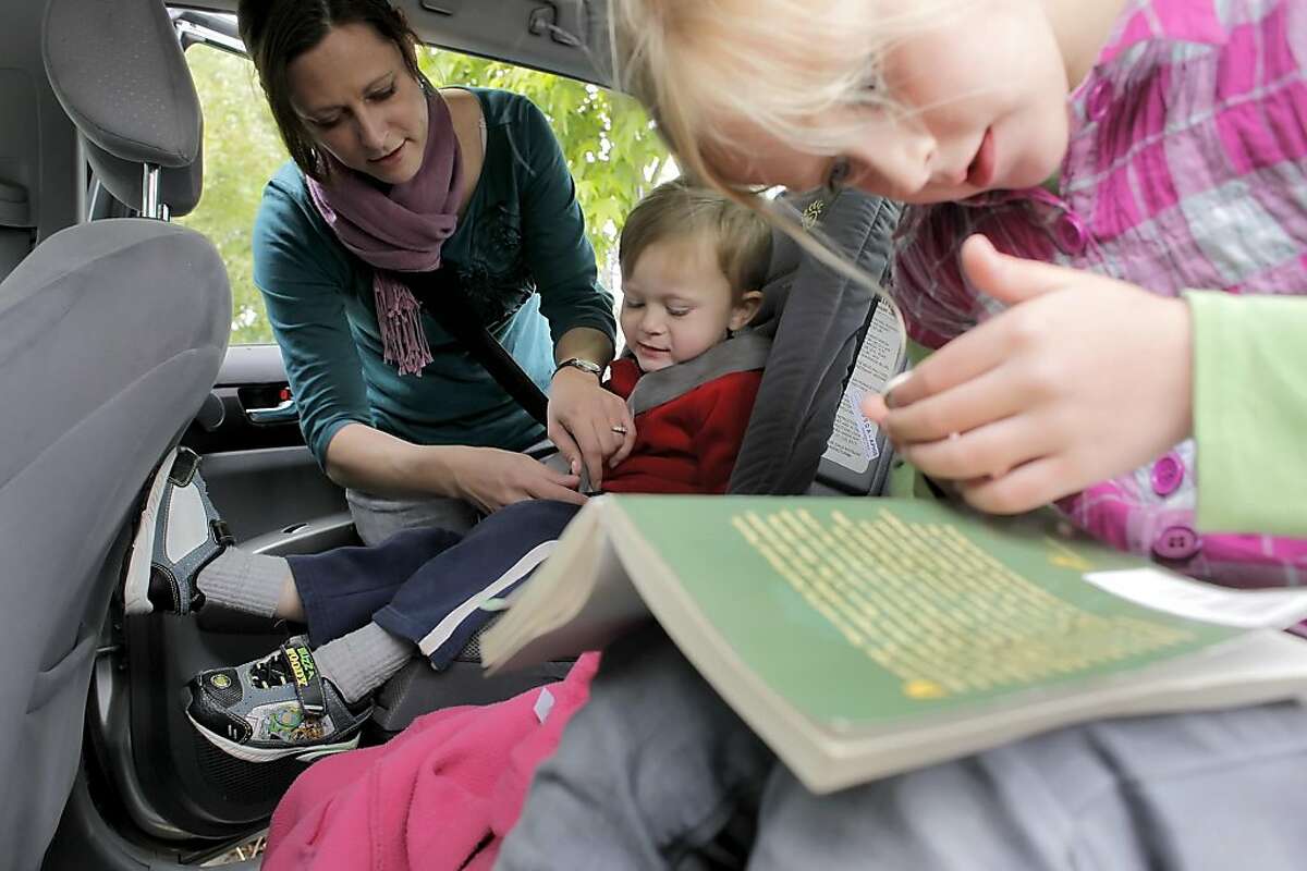 Mary Brune buckles up her son Sebastian in his car seat as her daughter Olivia plays with a silver dollar, Tuesday Monday May 17, 2011, in Alameda, Calif. Mary is extra cautious about the products she buys since eighty percent of baby products contain chemical flame retardants that are either untested or known to be toxic.