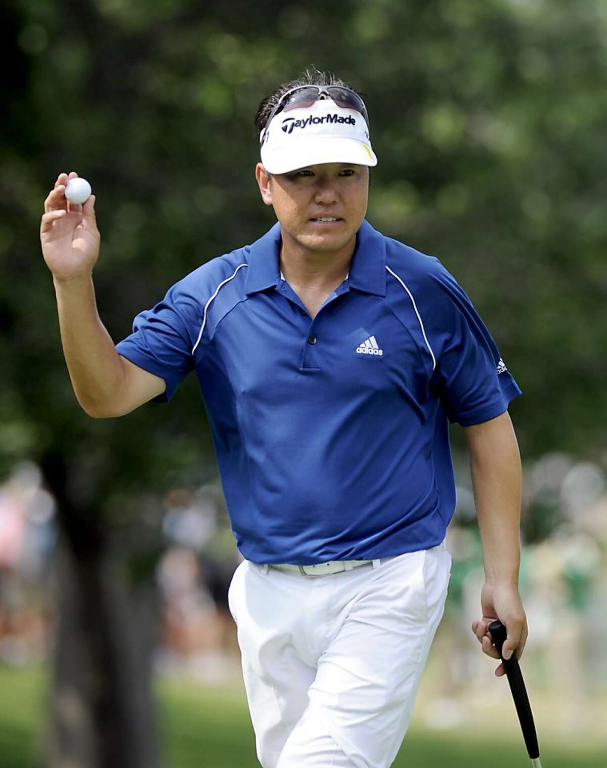 Charlie Wi, of South Korea, waves to the crowd after making a par on the 14th hole during the third round of play at the Colonial golf tournament in Fort Worth, Texas, Saturday, May 21, 2011.