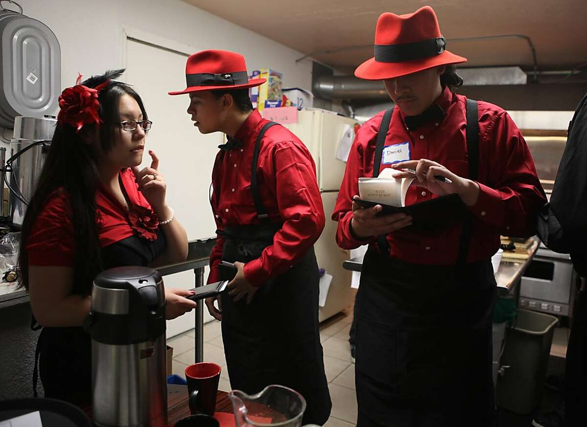 Interns Destiny Cravalho (left), 18 years old, and Andrew Urrutia (middle), 18 years old, in the kitchen while Daniel Bermudez (right), looks over orders as they host a swing dance dinner at Old Skool Cafe in San Francisco, Calif., on Friday, April 22, 2011. Old Skool Cafe is a program for youth that teaches them marketable culinary skills.