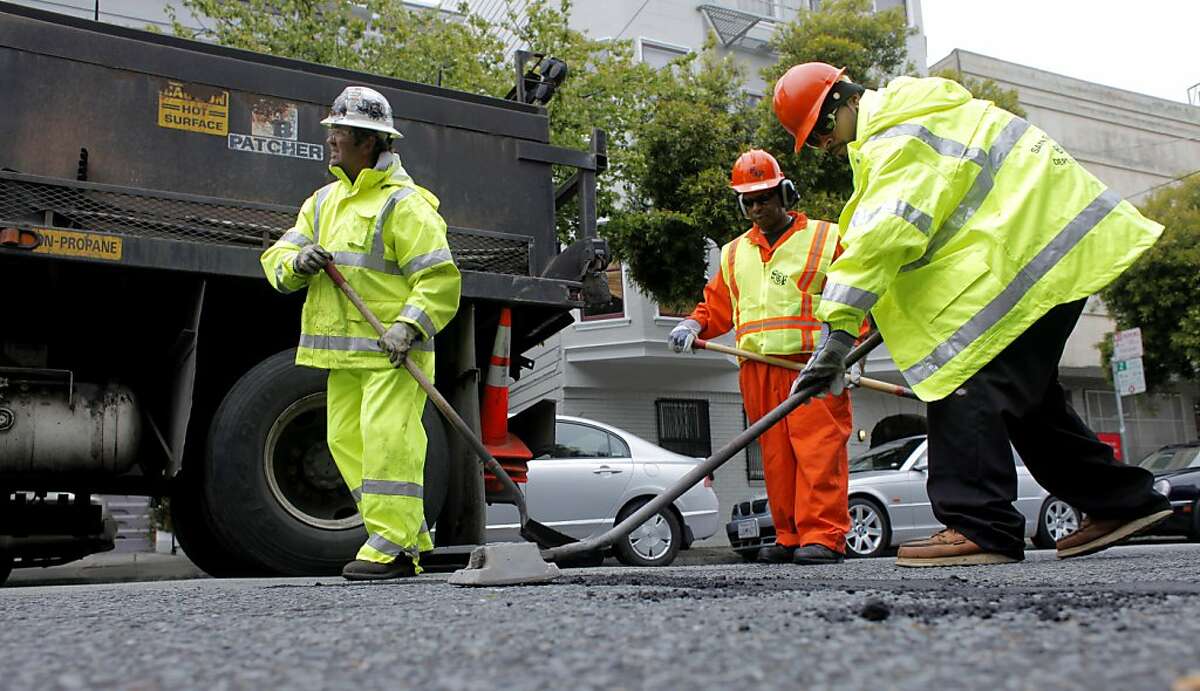 Crew members of the San Francisco Department of Public Works, Sean Healy, left, and Charles Bridgewater and Chris Solorzano fill potholes down Grove Street, Monday May 17, 2011, in San Francisco, Calif. San Francisco Mayor Ed Lee and several supervisors set to announce Tuesday their support of a proposed $248 million bond for the November ballot to fund street improvement.