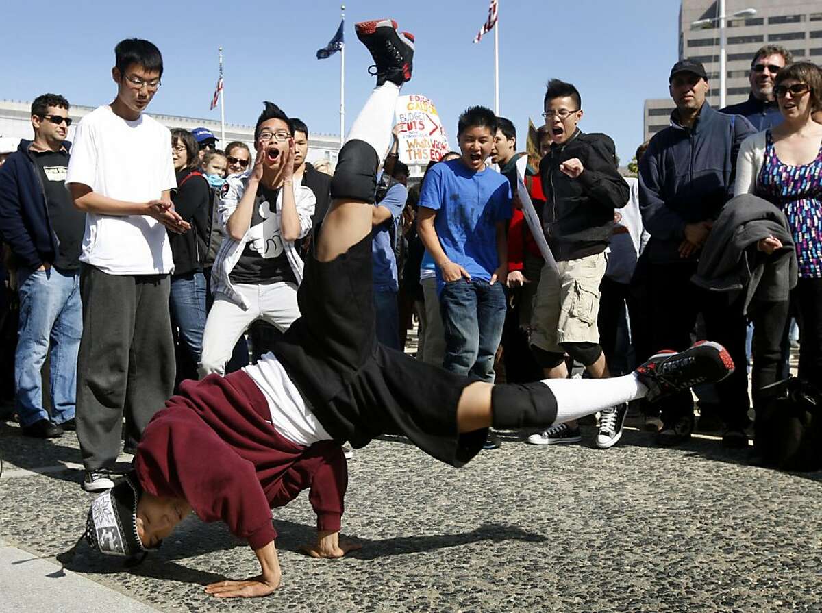 Alex Cho, who teaches breakdancing at Galileo High, entertains students and fellow teachers at a rally to protest against statewide budget cuts for education at Civic Center Plaza in San Francisco on Friday.