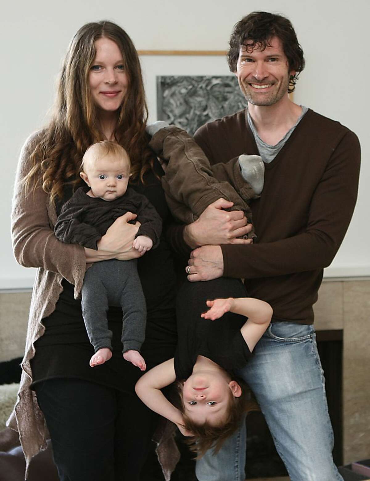 Chef Daniel Patterson holding Julian Patterson, 2 years old, with Alexandra Foote holding Louise Patterson, 3 months old on front of the fireplace at home in Oakland, Calif., on Thursday, April 21, 2011.