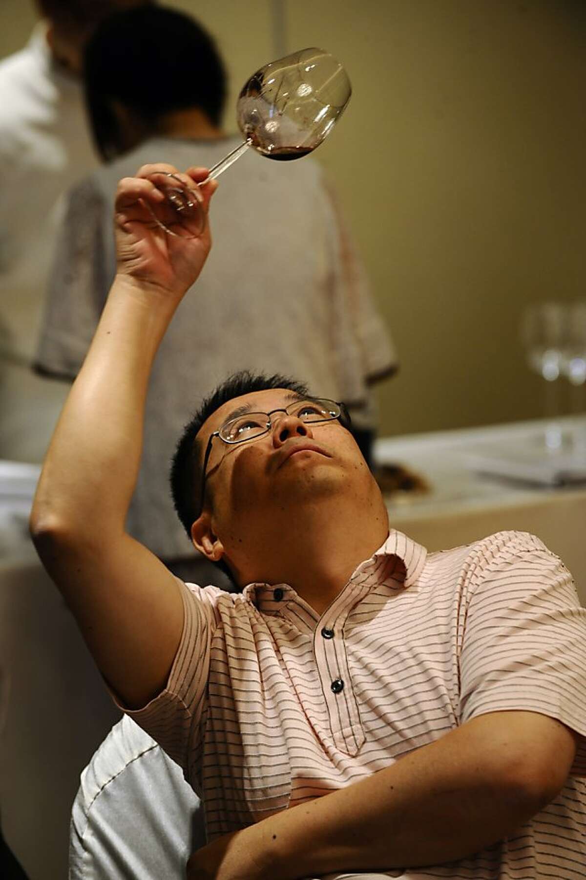 In a picture taken on September 12, 2009 a potential invester samples wine at a wine auction in Hong Kong. Hong Kong investors are turning to rare vintages as an alternative bet for good capital growth, a trend driven by an insatiable demand for imported wine in China.