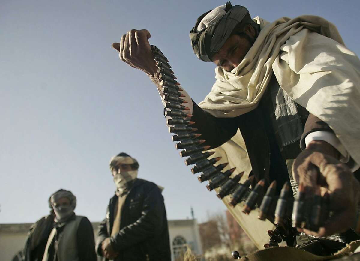 FILE- In this Dec. 28, 2010 file photo, a former Taliban fighter places a range of bullets before surrendering it to Afghan authorities, as part of a peace-reconciliation program in Herat, west of Kabul, Afghanistan. The death of Osama bin Laden is expected to spark debate within the Afghan Taliban about their ties to al-Qaida, a union the U.S. insists must end if the Afghan insurgents want to talk peace.
