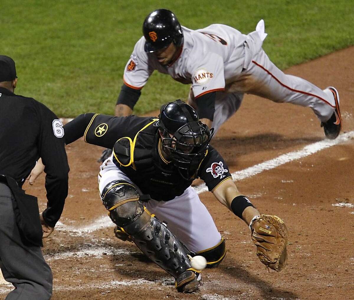 Pittsburgh Pirates catcher Chris Snyder, bottom, can't handle the throw from first baseman Lyle Overbay as San Francisco Giants' Darren Ford, top, scores from third on a ground out by Freddy Sanchez during the 10th inning of a baseball game in Pittsburghon Tuesday, April 26, 2011. The Giants won 3-2 in 10 innings.