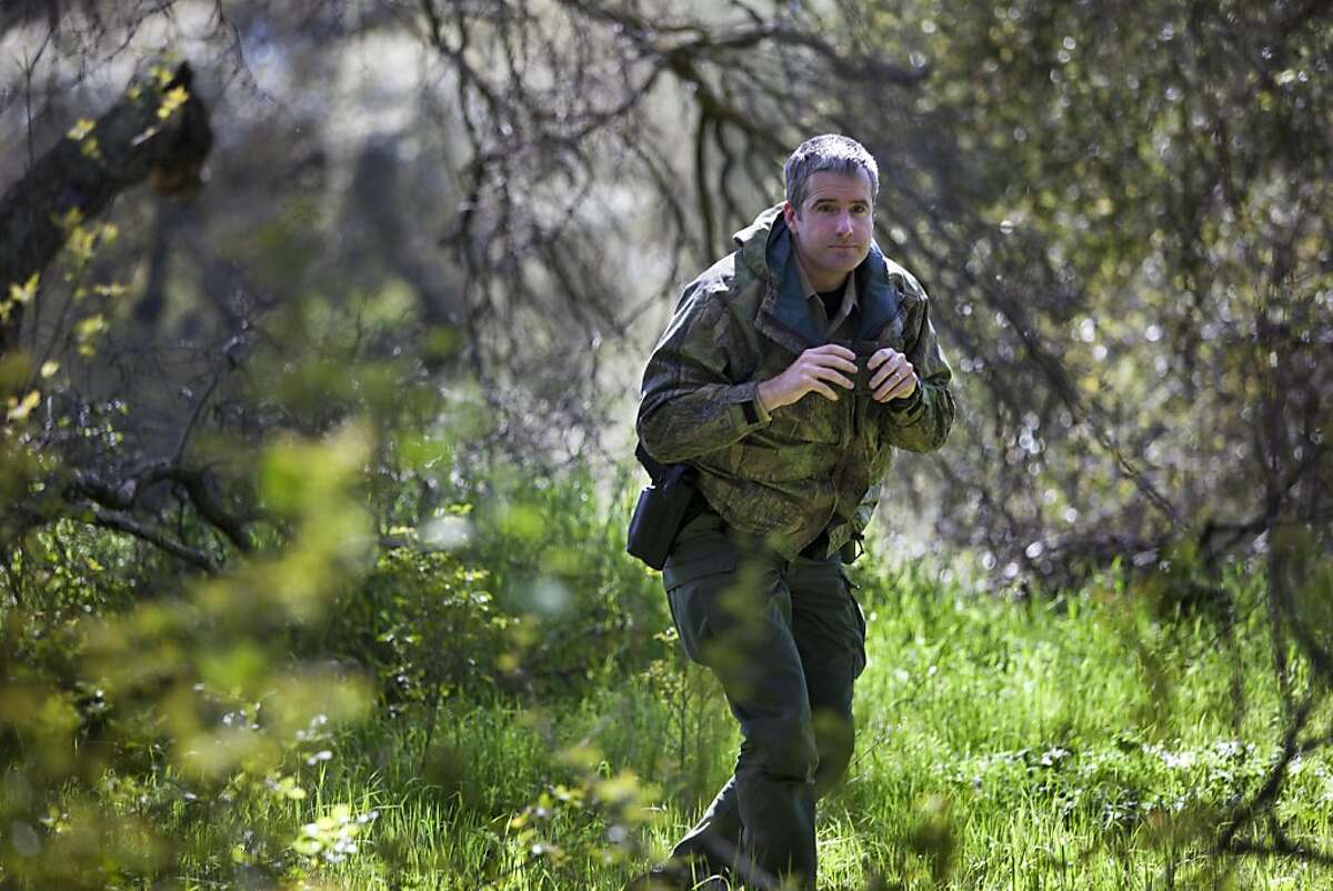 Patrick Foy, a warden with the Department of Fish and Game in Sacramento patrols along the American River Wednesday, March 30, 2011. He generally is on the look out for poachers and marijuana growers.