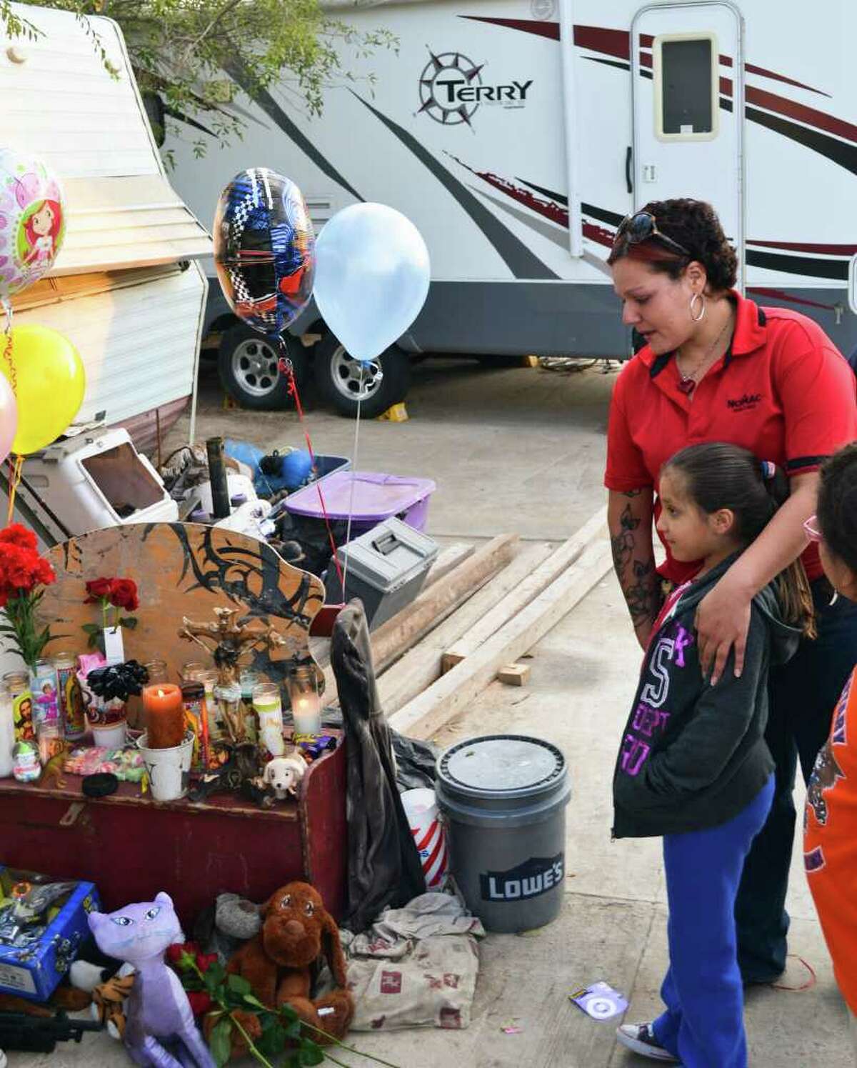 Naomi Salinas and her daughter Jannette drove across town to place flowers on the shrine for Rachelle, Timothy and Ramie Grimmer in front of the family’s RV in Laredo.