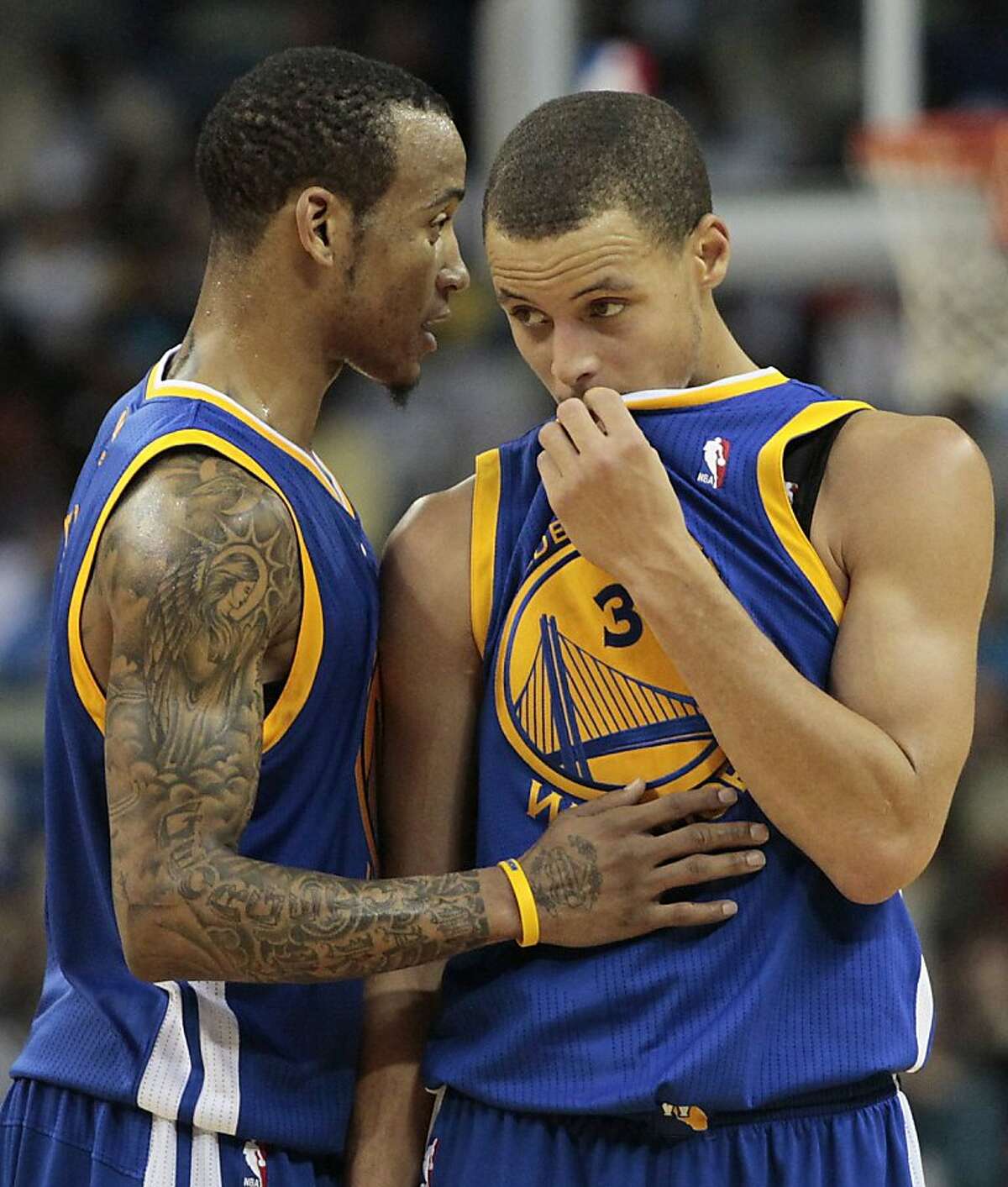 Golden State Warriors guard Monta Ellis, left, speaks with teammate Stephen Curry in the second half of an NBA basketball game against the New Orleans Hornets in New Orleans, Wednesday, Jan. 5, 2011. Ellis and Curry contributed 29 and 21 points, respectively, to Golden State's 110-103 win over New Orleans.