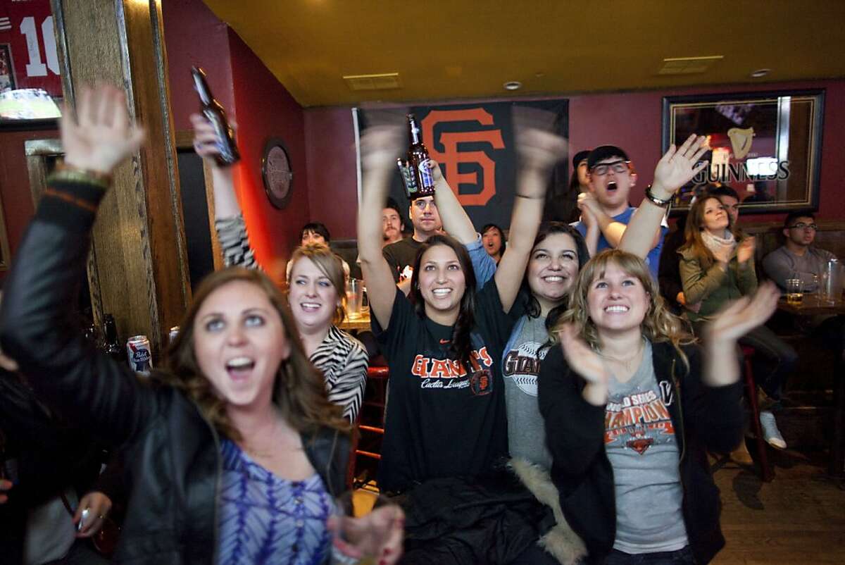 Caroline Grass (second from left), Sarah Baky (center), Steph Castro (second from right), and other SF Giants fans cheer for their team at Finnerty's on April 03, 2011 in New York City. Finnerty's has become a hang out for SF Giants fans in NYC.