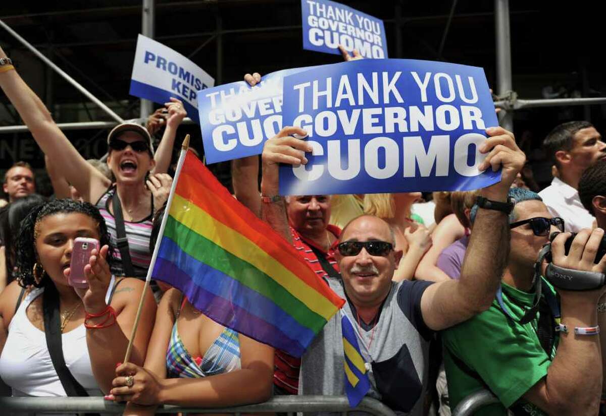 People hold signs thanking Gov. Andrew Cuomo during the New York City gay pride march June 26. After that landmark decision, the state could do more to improve the rights of transgender people, advocates say. (Stan Honda/AFP/Getty Images)