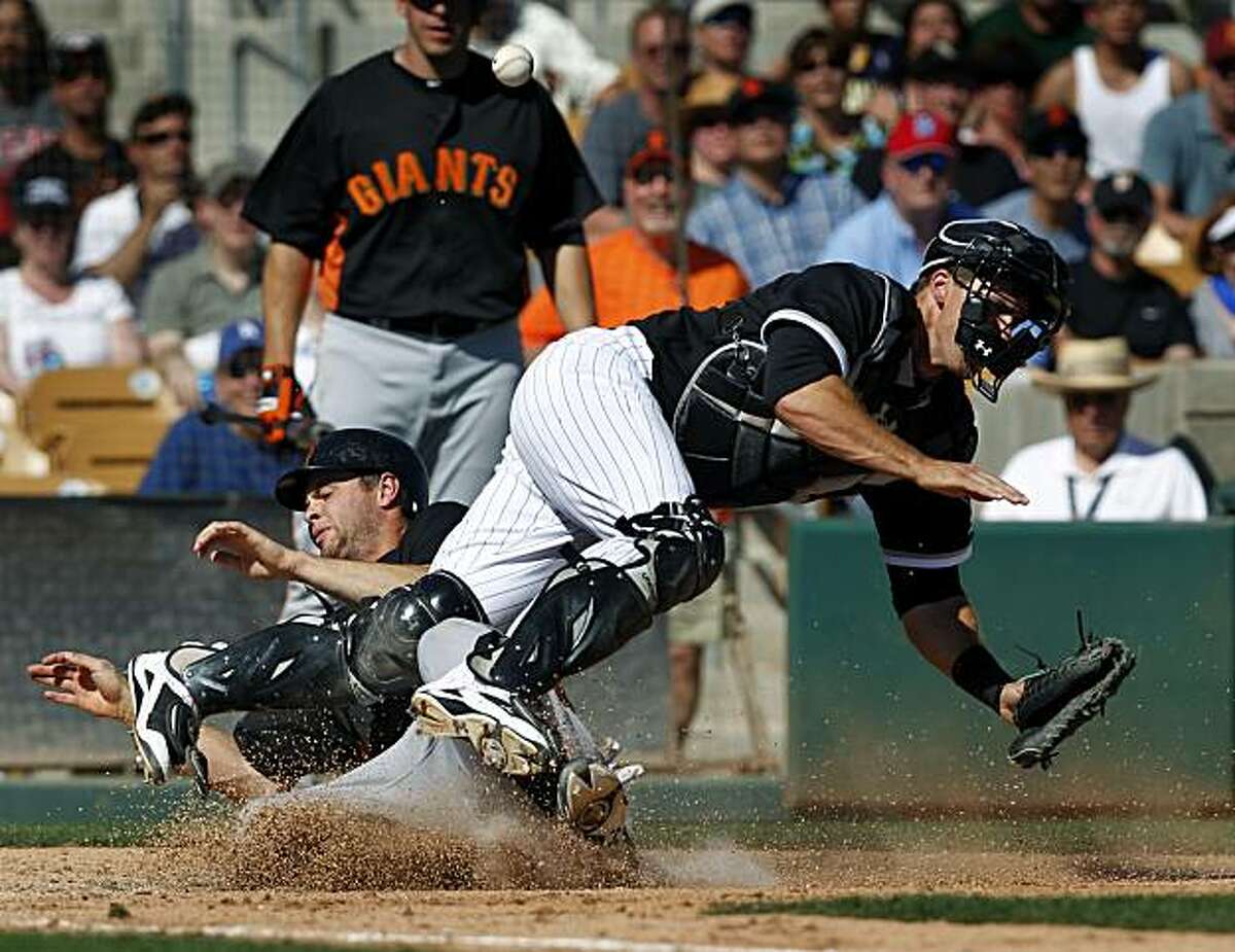 Brandon Belt scores with a hard slide on White Sox catcher Donny Lucy in the 7th inning of the Giants 5-3 win over the Chicago White Sox in a spring training baseball game at Camelback Ranch stadium in Glendale, Ariz. on Wednesday, March 16, 2011.