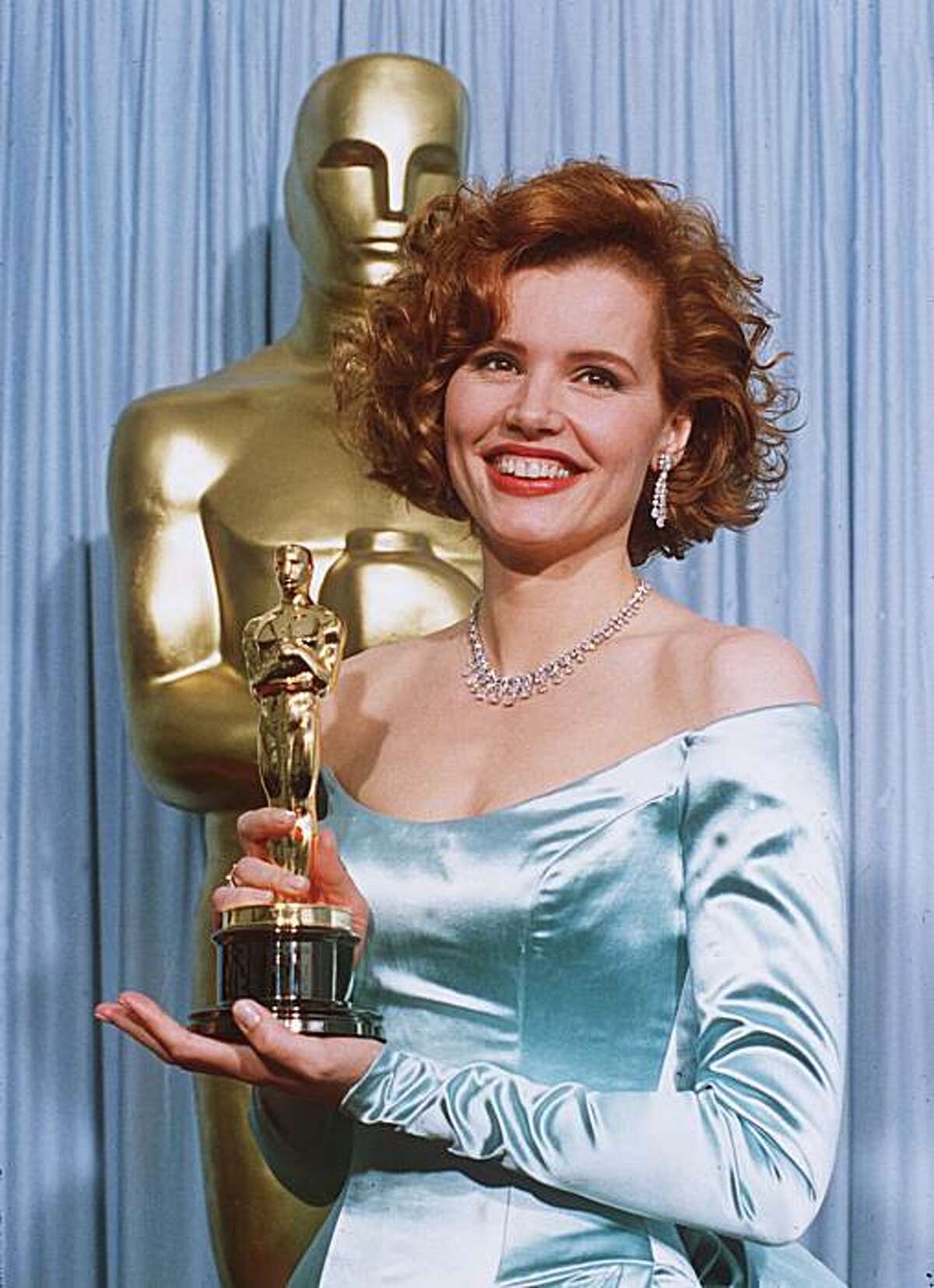 Geena Davis shows off her Oscar March 30, 1989 after winning Best Supporting Actress at the 61st Academy Awards for her role in the "Accidental Tourist." (AP Photo/ Lennox McLendon)