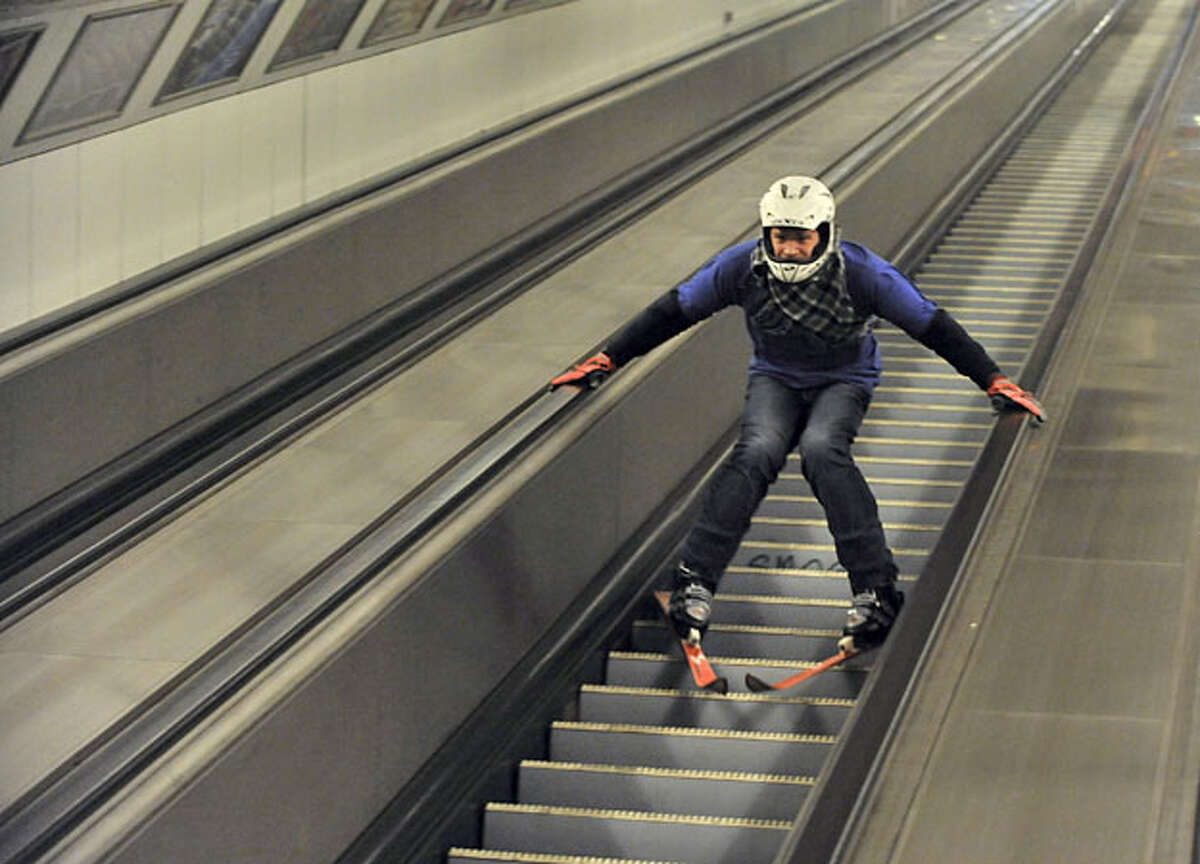 Young Hungarian stuntman, nicknamed "Szenty," skies down one of the escalators of a subway system in Budapest, Hungary, Sunday, May 9, 2010.