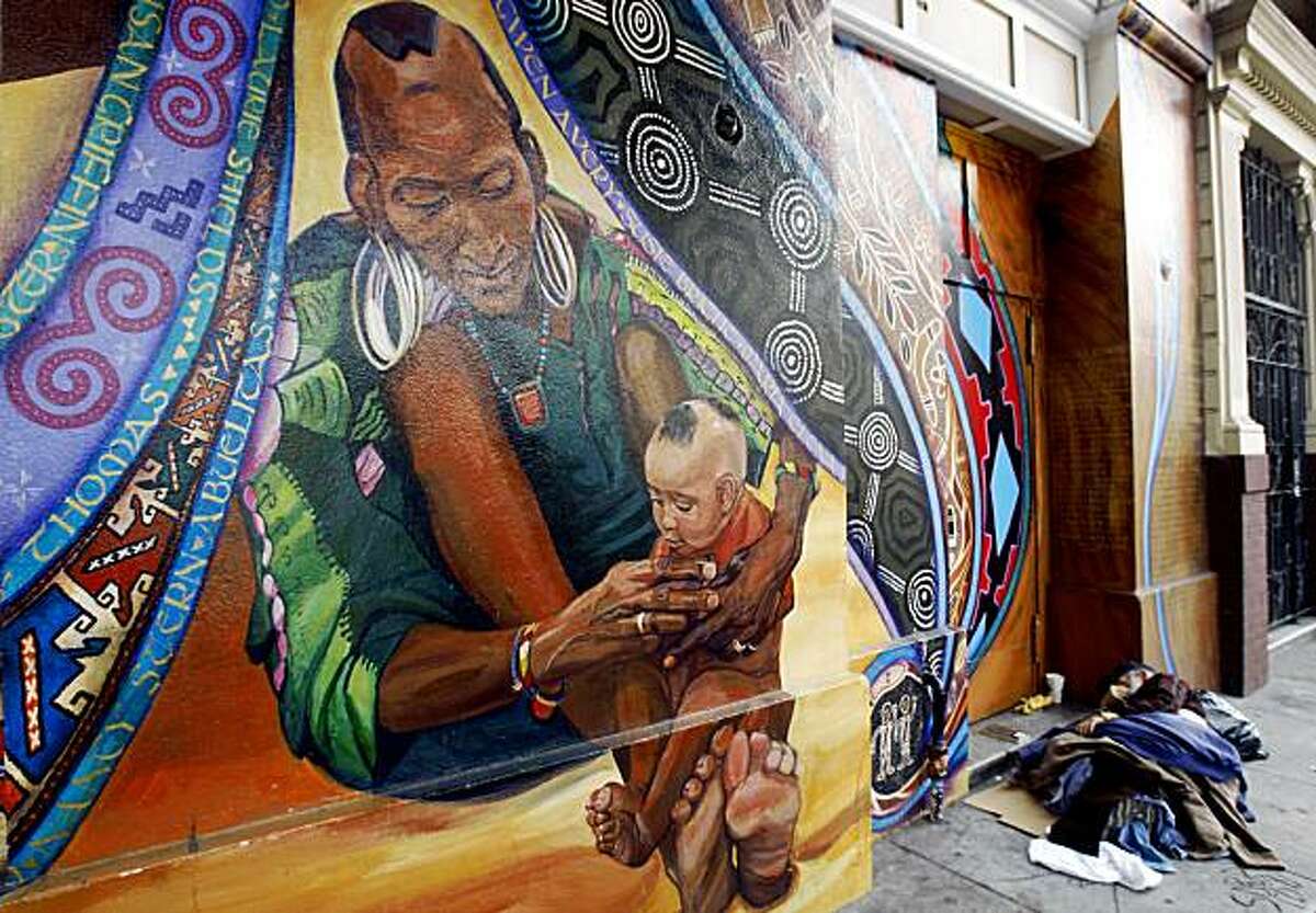 A man sleeps under a section of the mural titled "Maestrapeace", painted by seven female muralists, on the Women's Building on 18th Street in the Mission District in San Francisco, Calif., on Thursday, July 30, 2009. The mural is one of several featured in a book titled, "Street Art San Francisco," which highlights the colorful murals of the Mission District.