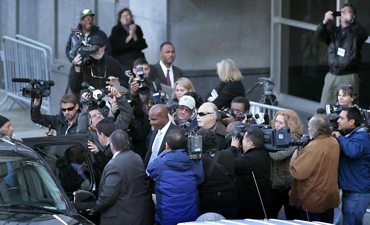 The media circles Barry Bonds as he leaves the Federal Court Building, Monday, March 21, 2011, in San Francisco, Calif. The first day of the perjury trial ended with jury selection.