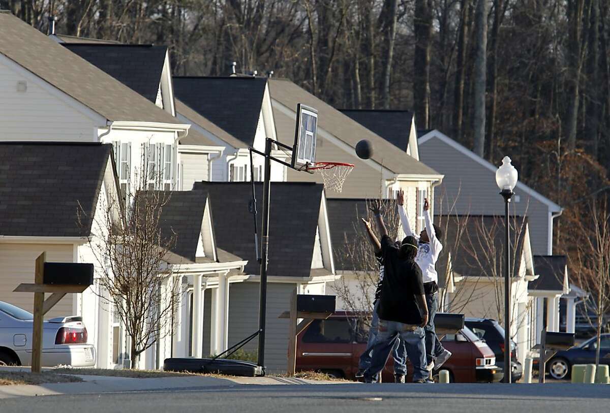 ** ADVANCE FOR USE SUNDAY, MARCH 27, 2011 AND THEREAFTER ** In this Wednesday, Feb. 16, 2011 picture, boys play basketball along Rockwood Road in the Peachtree Hills subdivision of Charlotte, N.C. Many people sought the American Dream in starter homes here. But in this and a neighboring subdivision is a bitter lesson in how the mortgage disaster of the last few years came about, and the story of the gambles and errors that pushed the economy, and neighborhoods like this, over a cliff.