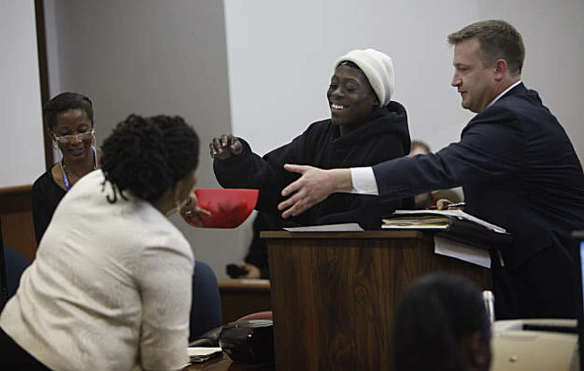 Tomiquia Moss (l to r), Community Justice Center coordinator, hands a bowl of candy to Lacrecia Hicks of San Francisco while attorney Russell Goodrow assits while appearing at the Community Justice Center Court on Tuesday, March 15, 2011 in San Francisco, Calif.
