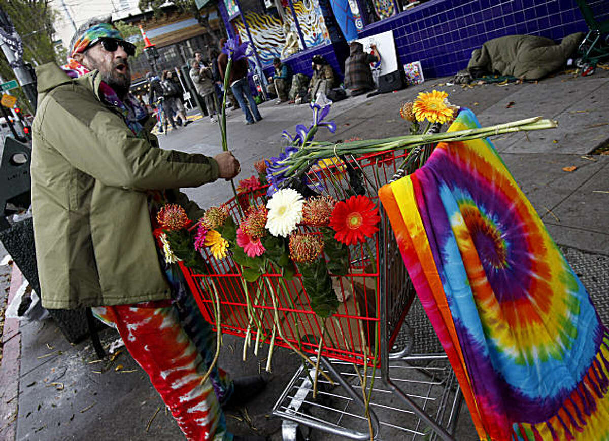 "Fast" Ed decorated a cart with flowers in memory of "Bear" Stanely while others talked about his legend in the background Sunday March 13, 2011. Augustus Owsley Stanley or "Bear" Stanley was remembered on the corner of Masonic and Haight Streets in San Francisco, Calif. by people who knew him and loved the Grateful Dead.