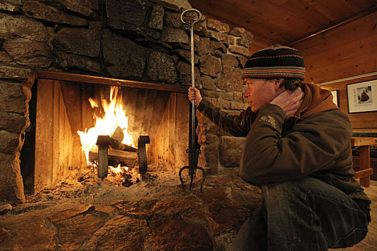 Peter Lehmkuhl, the general manager of the Sierra Club's Clair Tappaan Lodge mountain hostel, in Norden, Ca., high in the Sierra Nevada mountains, on Thursday March, 10, 2011. Lehmkuhl, tends to the lodge's fireplace where they use dried wood and small pieces to cut down on the amount of smoke released into the air.