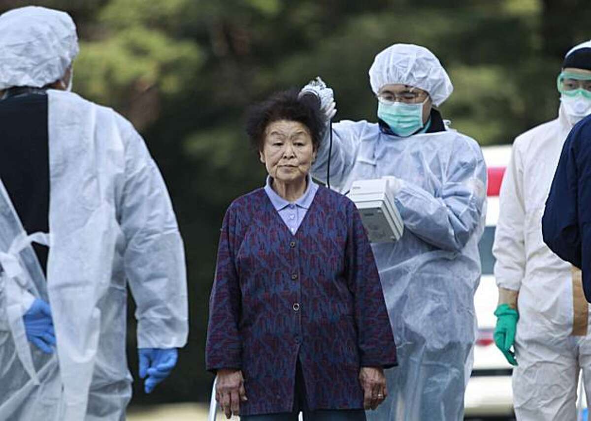 Residents evacuated from areas surrounding the Fukushima nuclear facilities damaged in Friday's massive earthquake, are checked for radiation contamination, Sunday, March 13, 2011, in Koriyama city, Fukushima prefecture, Japan.
