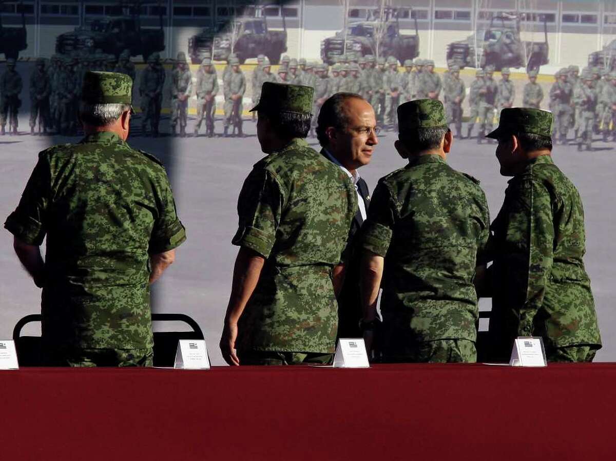 Mexican President Felipe Calderón (center rear) greets Mexican military officials during a dedication ceremony for the new army base on Thursday, Dec. 8, 2011 in Ciudad Mier, Tamaulipas, Mexico.