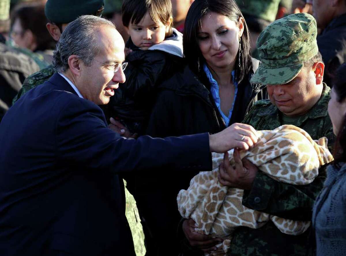 Mexican President Felipe Calderón (left) looks at a baby during a dedication ceremony for the new army base on Thursday, Dec. 8, 2011 in Ciudad Mier, Tamaulipas, Mexico.