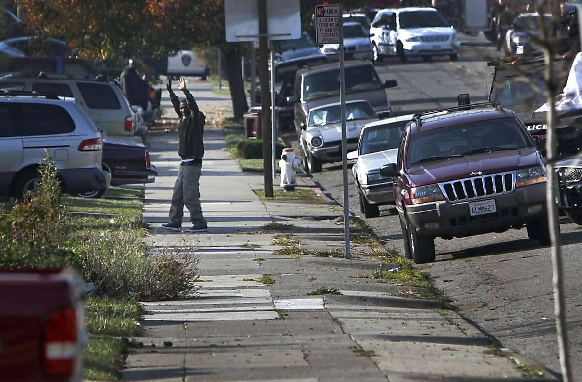 Detwone Watson, the suspect in a San Leandro Black Friday shooting, comes out of a home with his hands up after a standoff with police in Oakland, Calif., Thursday, December 8, 2011.