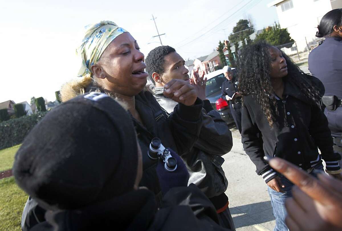 Terri Larkins, who said she was the sister of shooting suspect Detwone Watson, cries with relief after he came out of a home with his hands up and turned himself over to police in Oakland, Calif., Thursday, December 8, 2011.