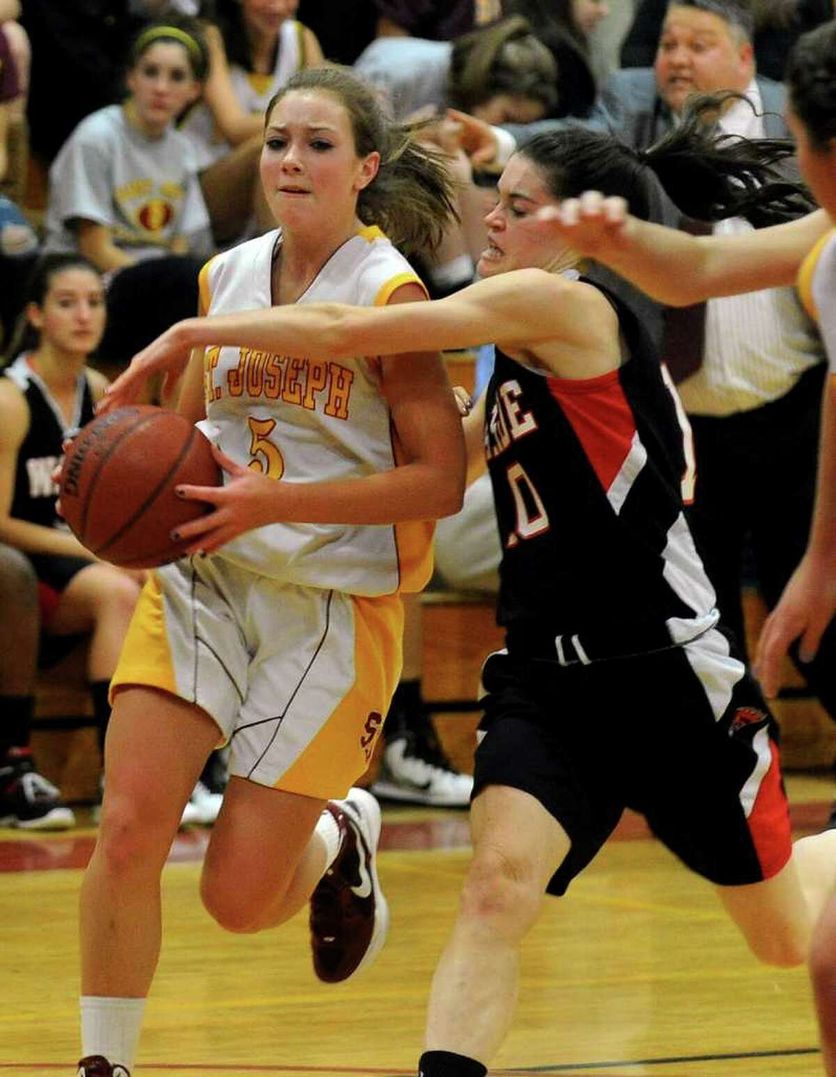 Fairfield Warde's #10 Kate Kerrigan, right, looks to steal away the ball from St. Joseph's #5 Lauren DellaVecchia, during girls basketball action in Trumbull, Conn. on Friday Dec. 9, 2011.
