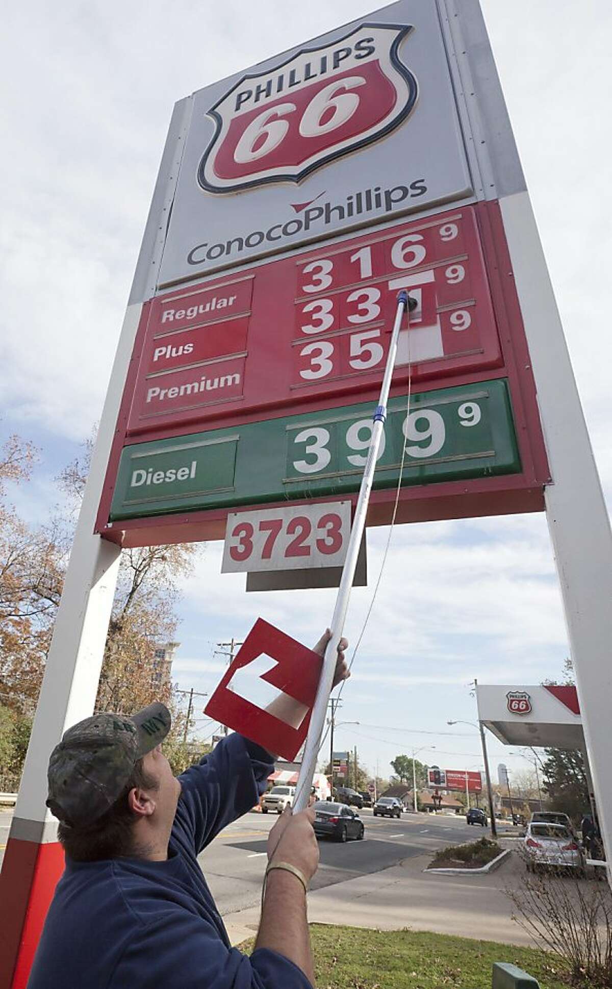 Store manager Joseph Sublett changes gasoline prices to reflect a three-cent drop at a Little Rock, Ark., Conoco-Phillips station Thursday, Dec. 1, 2011. At the pump, retail gasoline prices slipped by less than a penny to $3.292 per gallon, according to AAA, Wright Express and Oil Price Information Service. (AP Photo/Danny Johnston) Ran on: 12-10-2011 The high price of gas, caused by high oil prices, is the reason behind record spending.
