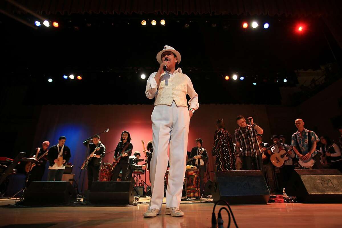 Carlos Santana (center) speaks to students gathered in the auditorium before performing at his alma mater Mission High school in San Francisco, Calif. on Monday, October 24, 2011.