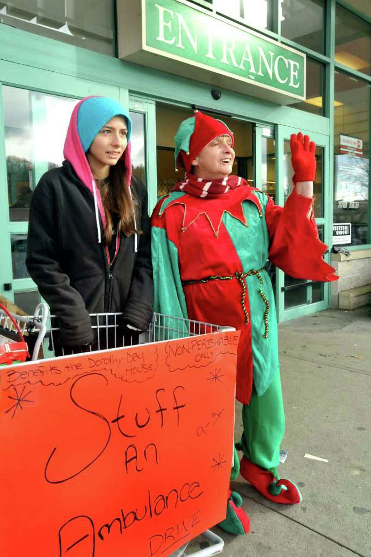 Darlene Cummings, 17, and her mom, dressed as an elf, Mary Anne Cummings, collect food for the Holiday Food Drive sponsored by the Danbury Ambulance Service to benefit Dorothy Day Hospitality House outside the A&P Super Food Mart in the North Street shopping center Saturday, Dec. 10, 2011.