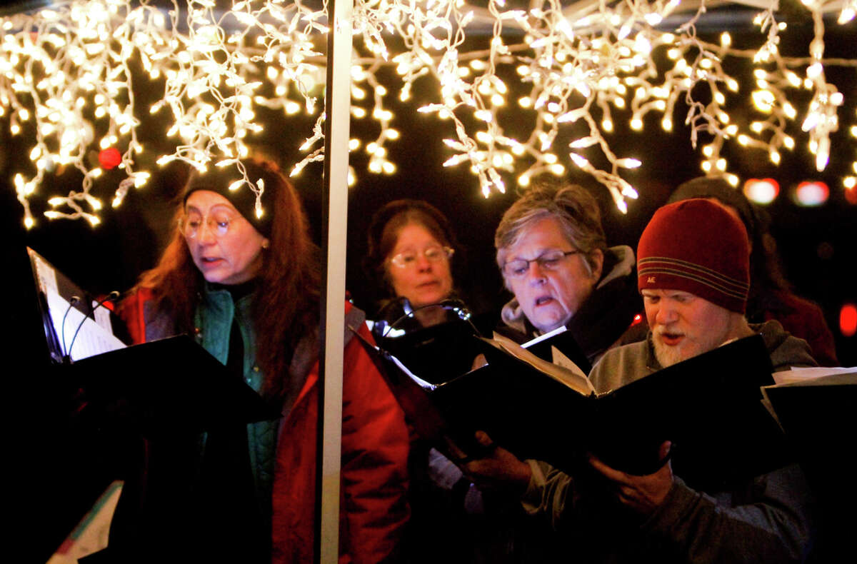 The Seattle Bach Choir sings Christmas carols at the Green Lake Pathway of Light celebration along the Green Lake Trail in Seattle on Saturday, Dec. 10, 2011. Thousands gather to walk around the lake and listen to holiday performances. Many people wear holiday lights or adorn their dogs in them and walk around the lake. This event has been held in Seattle for the past 35 years.