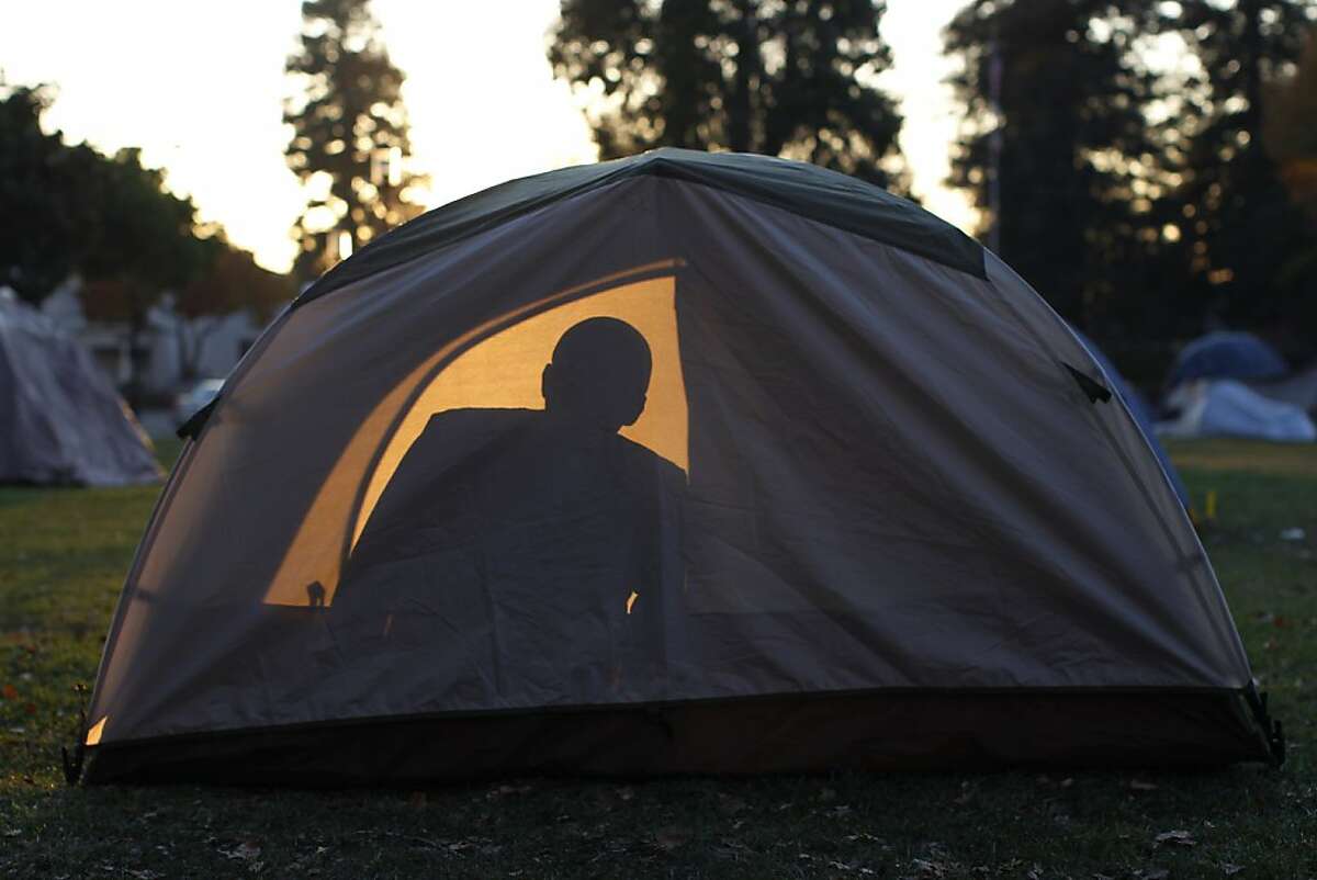 An Occupy Berkeley demonstrator, name withheld, sits inside his tent at the group's encampment at Civic Center Park in Berkeley, Calif. on Friday, Dec. 9, 2011.
