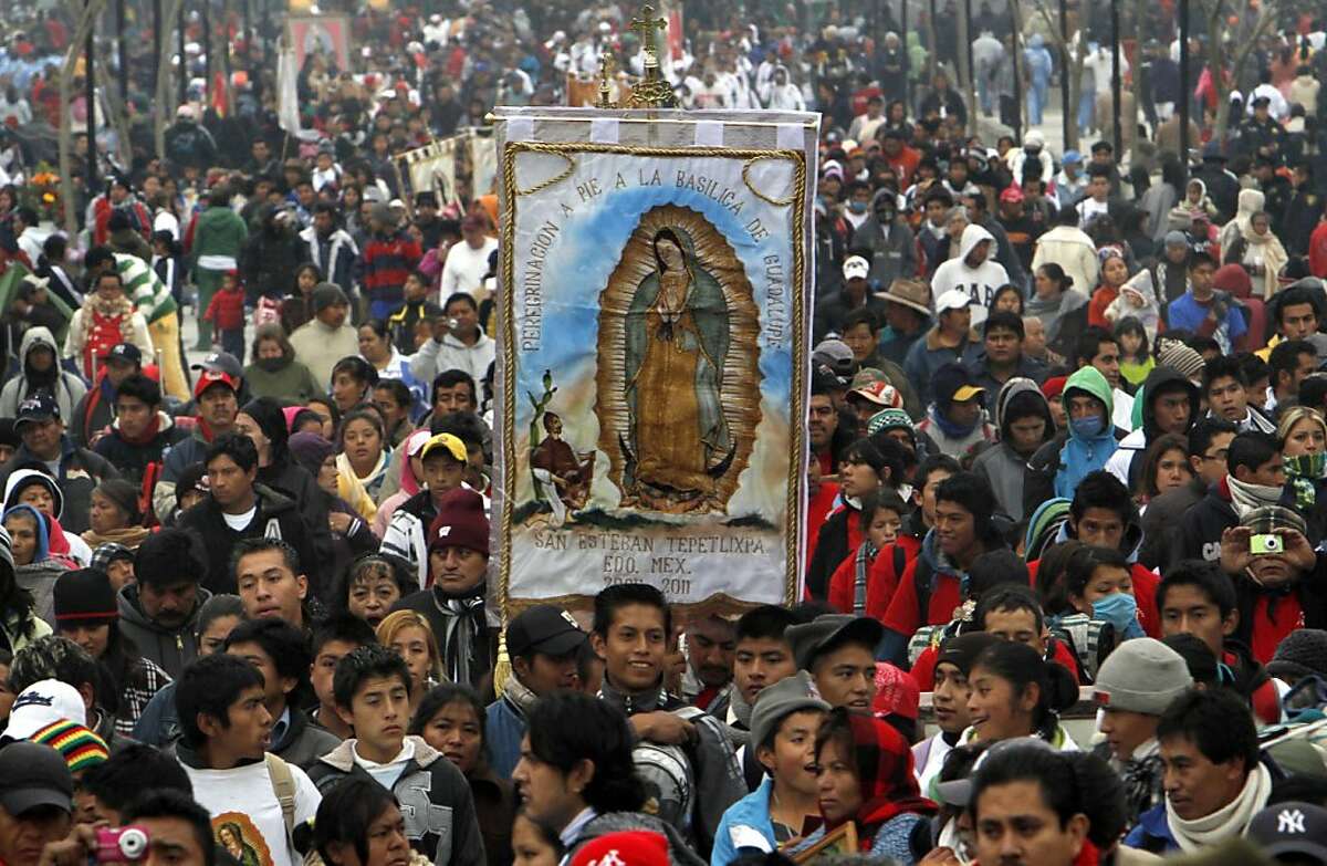Pilgrims carry an image of Our Lady of Guadalupe toward the Basilica of the Virgin of Guadalupe in Mexico City, Sunday Dec. 11, 2011. Hundreds of thousands of Mexicans are making the pilgrimage to the shrine in anticipation of the Catholic icon's feast day on Dec. 12. Also known as La Morenita, Our Lady of Guadalupe is Mexico's most popular religious and cultural image. (AP Photo/Marco Ugarte)