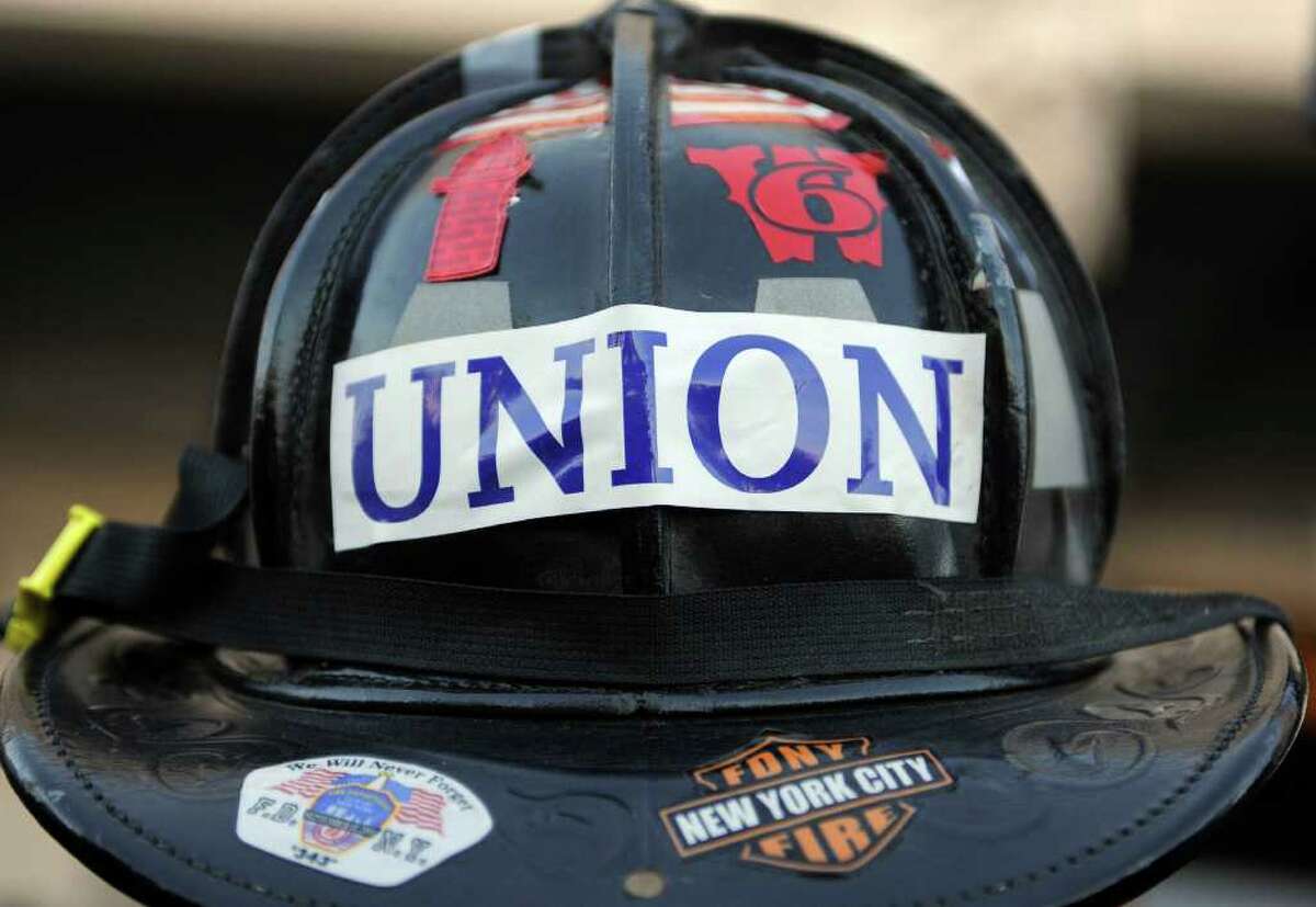 Mike Osiecki of South Fire District IAFF Local 3918, of Middletown, wears his fire helmet during a rally of union workers in support of unionized public employees in Wisconsin, at the Capitol in Hartford, Conn., Wednesday, Feb. 23, 2011. Dan Malloy addressed the crowd even as his administration plunged toward a fight over pay and pensions.