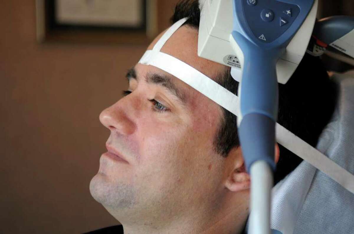 Client Ryan Kirk, of Bethel, sits in Dr. Tarique Perera's office in Greenwich Monday, Nov. 21, 2011. Dr. Tarique Perera, who practices in Danbury and Greenwich, is one of the nation's leading experts on the new science of using highly focused magnetic pulses to stimulate key neurons in the brain. It's called Transcranial Magnetic Stimulation (TMS) therapy.