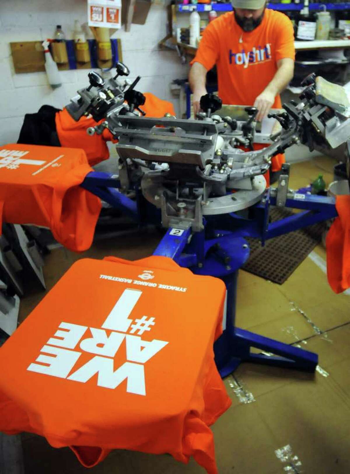 Drew Delfavero, a printer for Holy Shirt!, makes shirts that say "We Are #1" at their shop in Syracuse , N.Y., Monday, Dec. 12, 2011. The shirts are to celebrate the announcement of the Syracuse basketball team being voted No. 1 in the country in The Associated Press, ESPN and USA Today Top 25 polls. The t-shirts are being printed to fill orders placed by local stores and shops.