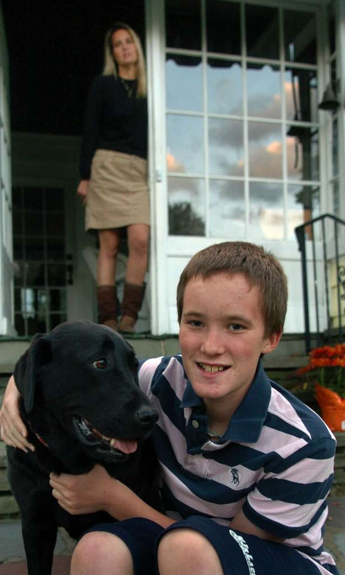 Charlie Snedaker, 12, poses with his dog Lucy while at home in Norwalk, Conn. on Wednesday Oct. 07, 2009. His mom Price stands in the doorway in the background. Charlie has had several severe concusions, five which happened in the past nine months alone.