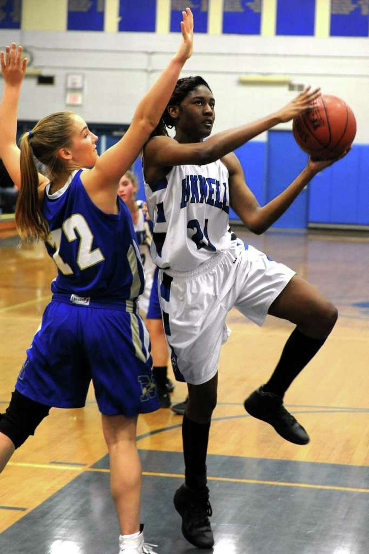 Bunnell's Shaquira Palmer drives to the net past Newtown's Carly Iwanicki during girls basketball action at Bunnell High School, in Stratford, Conn. Dec. 12th, 2011.