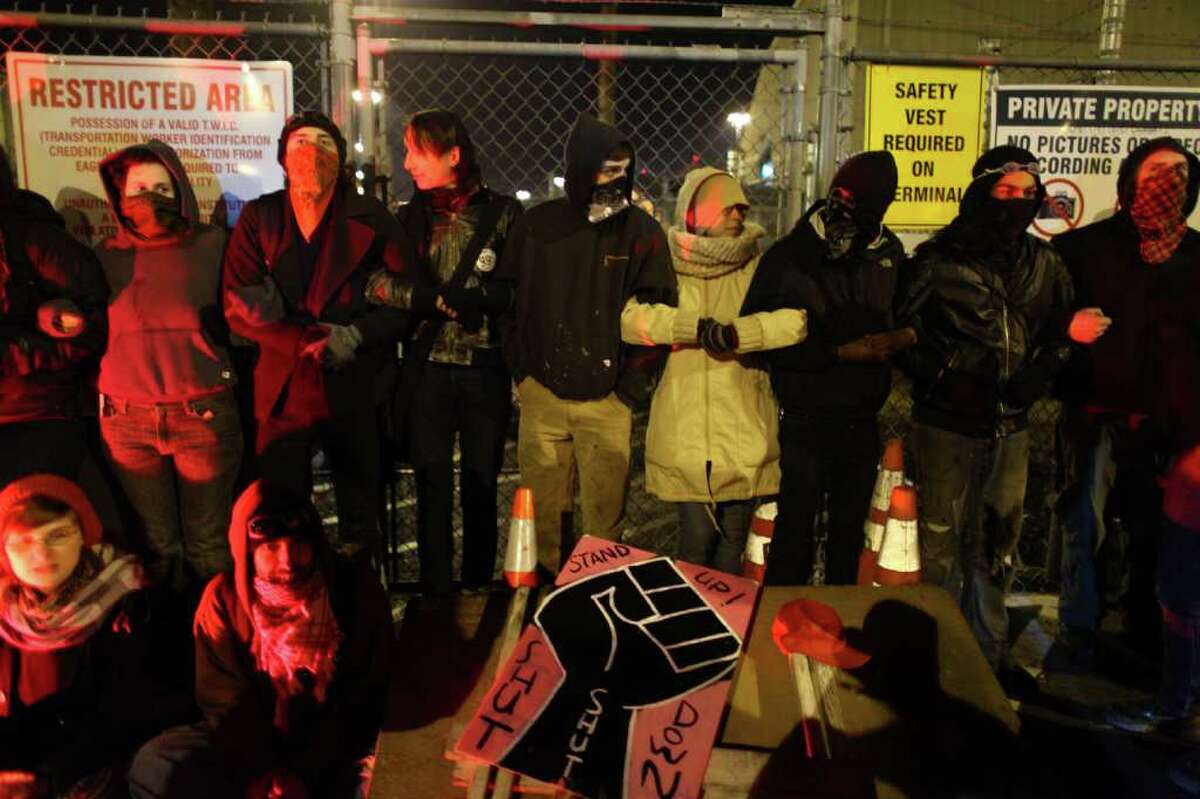 Protesters block entry to a gate at the Port of Seattle on Monday, December 12, 2011 at the Port of Seattle. Hundreds of anti-Wall Street protesters gathered at the port and tried to shut down operations. Protesters scuffled with police during the rally and police used pepper spray and two flash-bang grenades to disperse the crowd after a protester threw a lit road flare toward officers. Another threw red paint on officers.