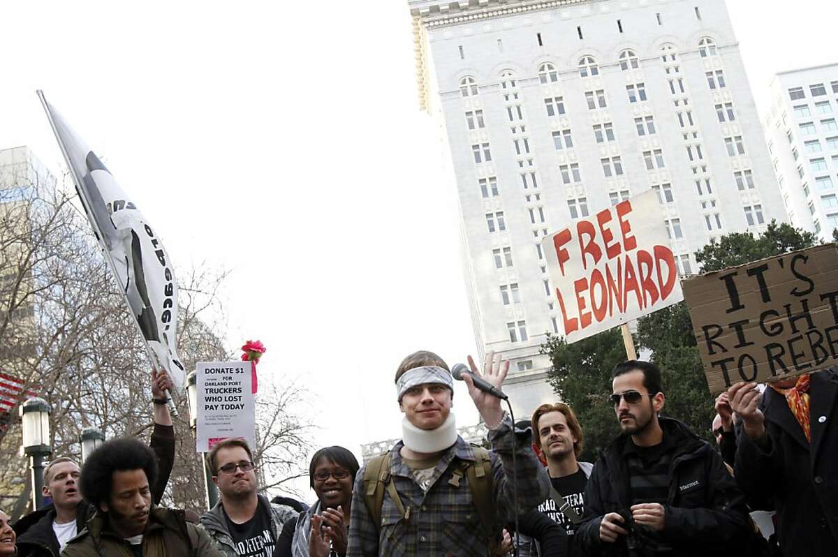 Scott Olsen, center, acknowledges the crowd and speaks publicly for the first time since being hit in the head with a tear gas canister in October. Olsen marched with Occupy Oakland protestors to the port to shut it down in Oakland, Calif., Monday, December 12, 2011.