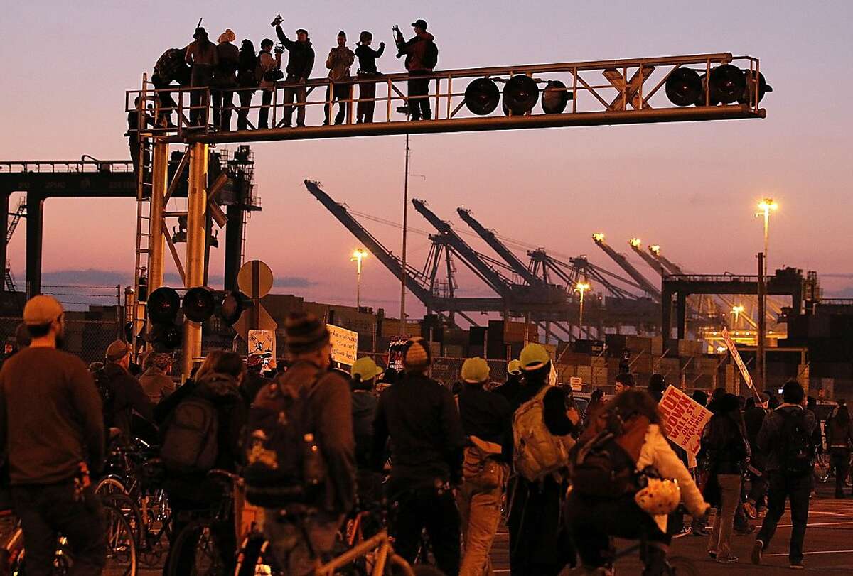 OAKLAND, CA - DECEMBER 12: Occupy protestors stand on a railroad crossing during a march at the Port of Oakland on December 12, 2011 in Oakland, California. Following a general strike coordinated by Occupy Oakland that closed the Port of Oakland on November 2, Occupy Wall Street protestors are attempting to shut down all West Coast ports in Los Angeles, San Diego, Oakland, Portland, Seattle and Tacoma. (Photo by Justin Sullivan/Getty Images)