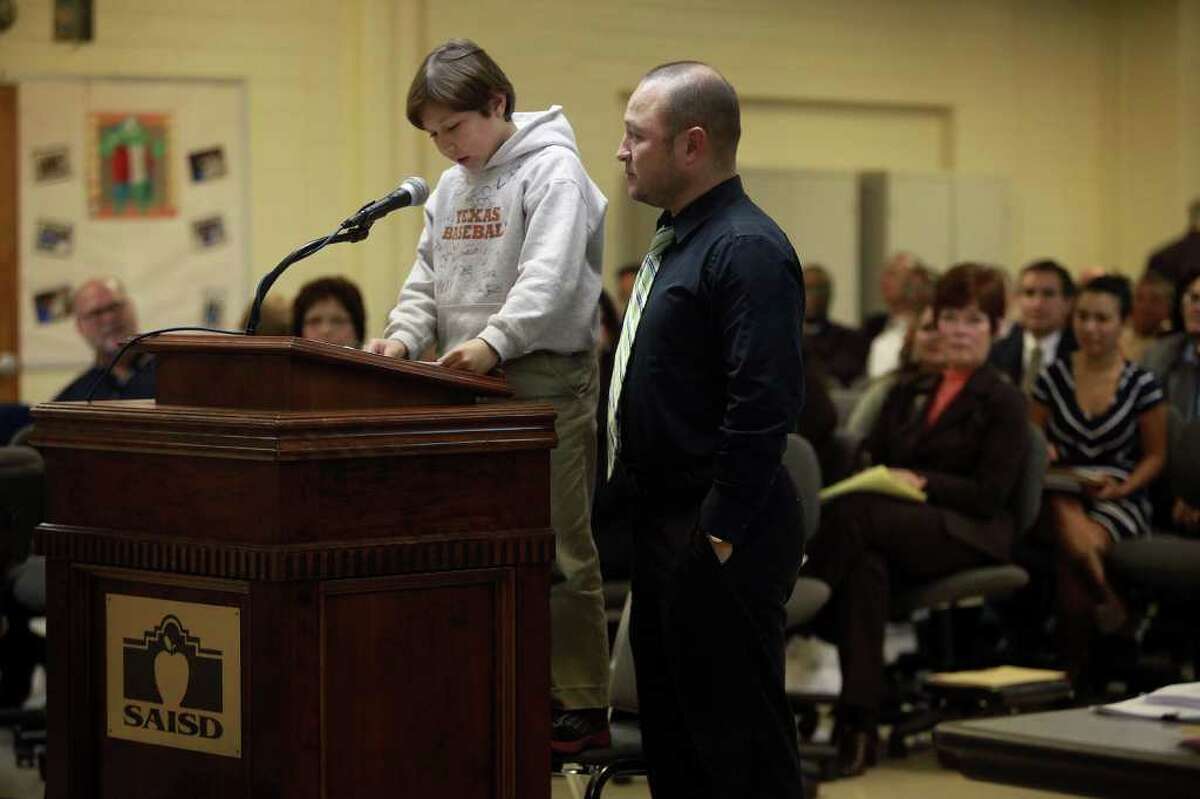 Art Gonzalez stands by as his son, 9-year-old soccer goalie Bishop Gonzalez, speaks about playing soccer in Alamo Stadium.