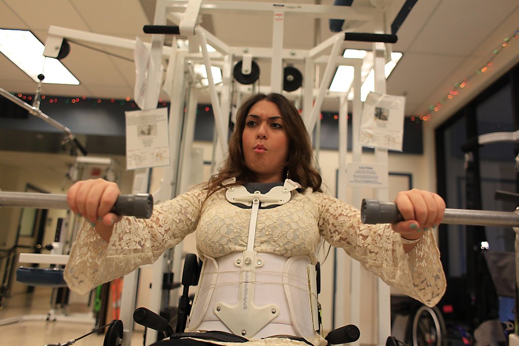 Katy Sharify (left), who received stem cell therapy before the study she  was part of was cancelled, moves between exercise machines in the Cypress  Semiconductor Spinal Cord Rehabilitation Gym with help from