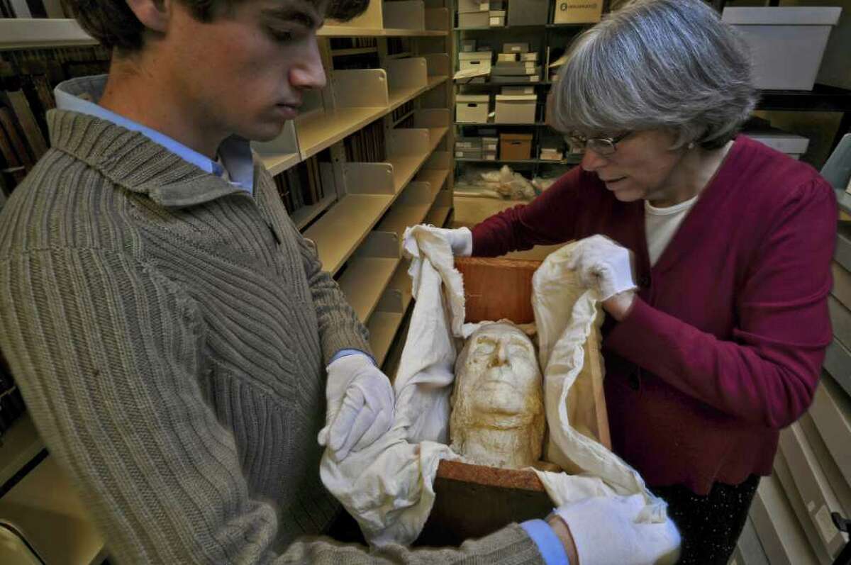 Annette LeClair, librarian and head of technical services for Union College's Schaffer Library, right, and digital projects assistant Matthew Connolly, left, unwrap a plaster death mask from 1911 of Union College graduate John Bigelow, in the Special Collections storage area of the library on Tuesday Dec. 13, 2011 in Schenectady, N.Y. Bigelow was a founder of the New York Public Library, consul general to Paris for President Abraham Lincoln and a friend to Charles Dickens and other literary figures. An exhibit marking the centennial of his death begins in the library on Dec. 19. (Philip Kamrass / Times Union )