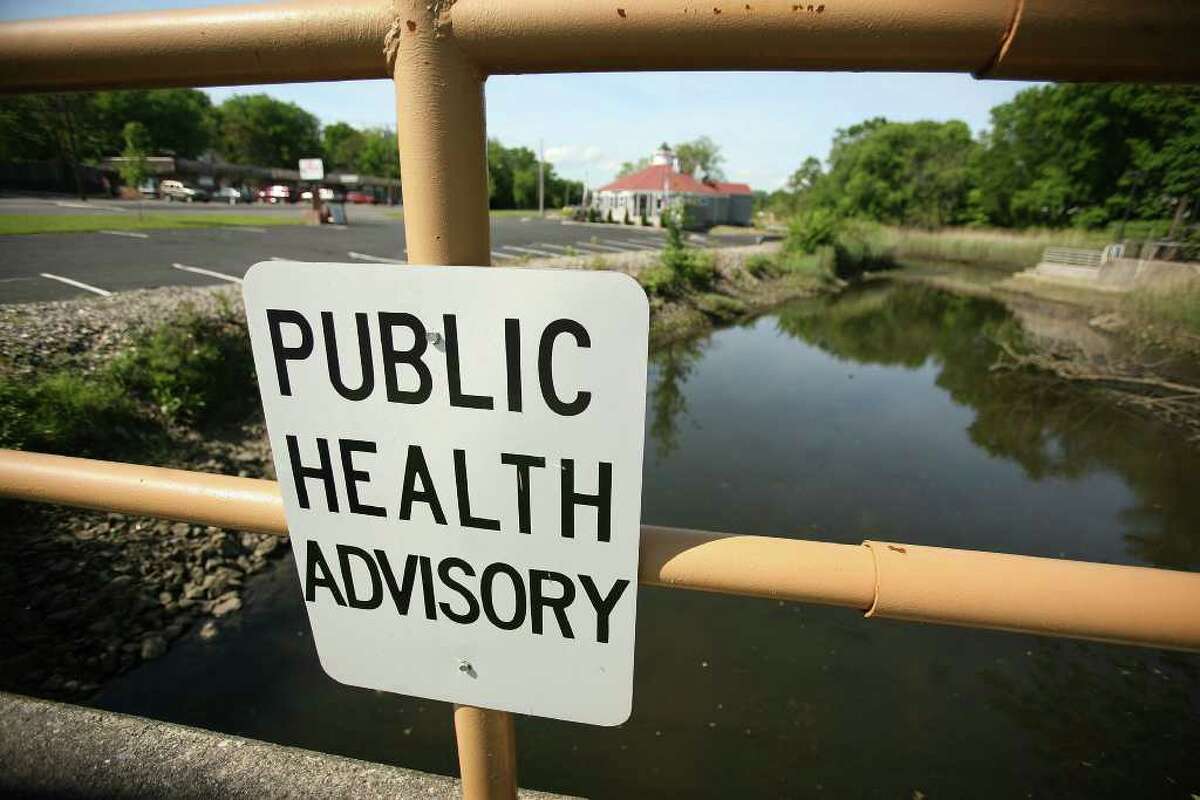 Public health warning signs at Ferry Creek in Stratford. A Connecticut Post report found more than a dozen Stratford residents bought homes in town without knowing the properties are what?