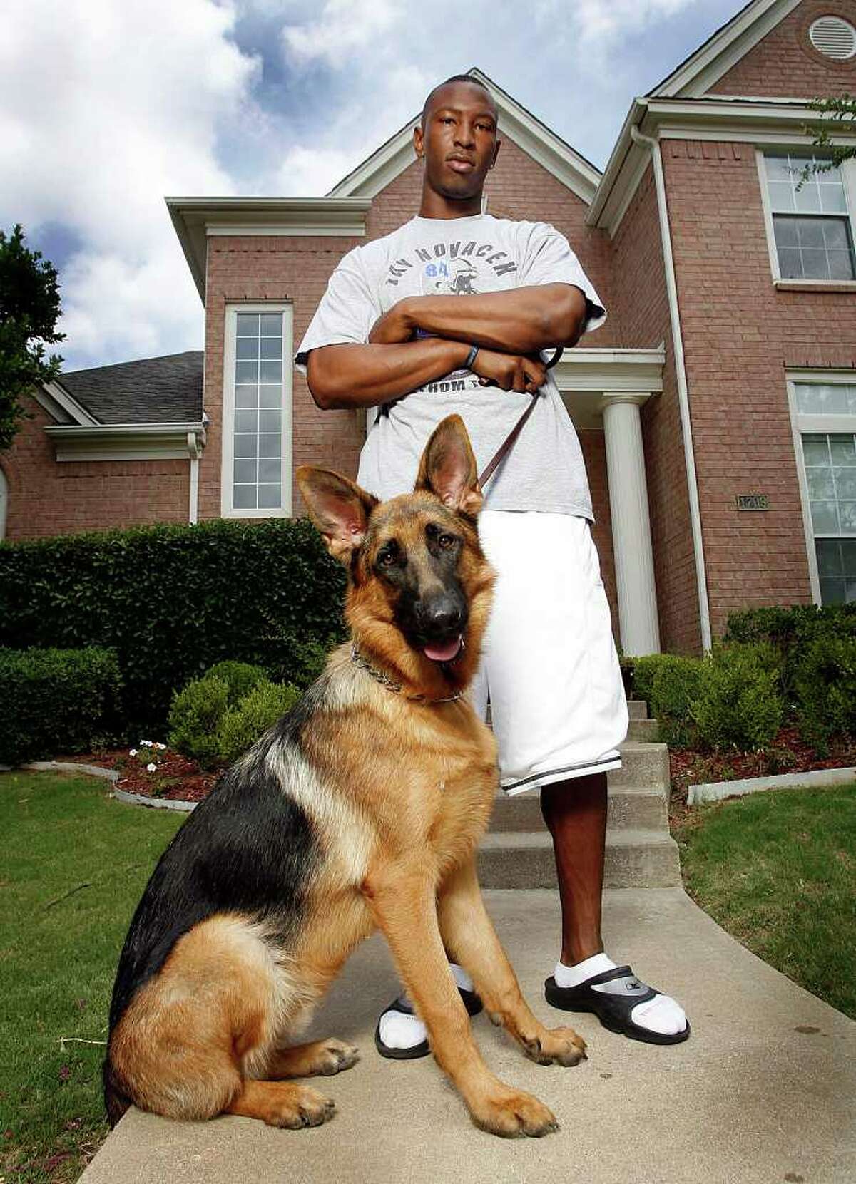 Dallas Cowboy wide receiver Sam Hurd poses with his German shepherd watchdog Butch in front of his in Irving home on June 25, 2008.